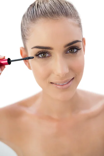 Smiling woman applying mascara — Stock Photo, Image