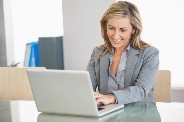 Affärskvinna som använder en bärbar dator på ett kontor — Stockfoto