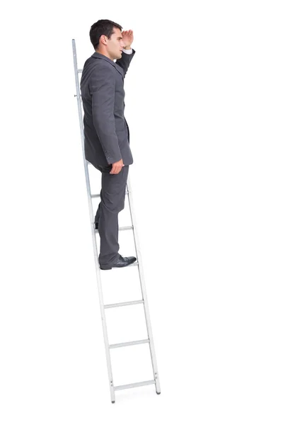 Jovem empresário em pé na escada olhando para longe — Fotografia de Stock