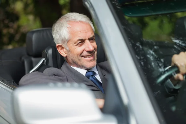 Uomo d'affari sorridente guida cabriolet costoso — Foto Stock