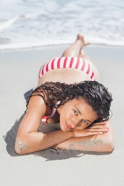Brunette woman lying down on beach — Stock Photo, Image