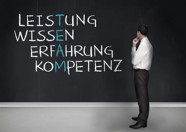 Κομψό επιχειρηματίας κοιτάζοντας επιτυχία όρους, γραμμένο στα γερμανικά — Φωτογραφία Αρχείου