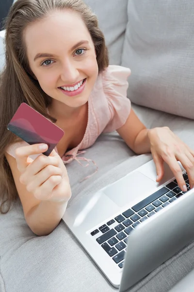 Mujer de compras en línea con su portátil sonriendo a la cámara —  Fotos de Stock