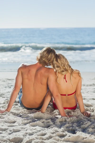 Rear view of a happy tanned couple sitting — Stock Photo, Image