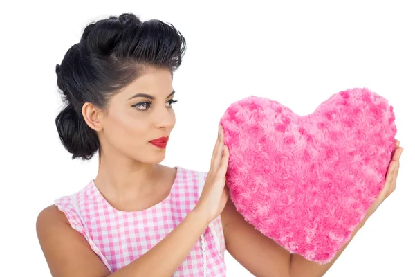 Charming black hair model holding a pink heart shaped pillow — Stock Photo, Image