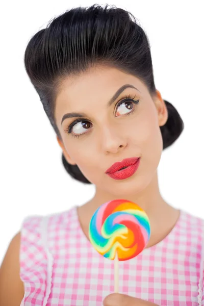 Benieuwd zwart haar model houden een gekleurde lolly — Stockfoto