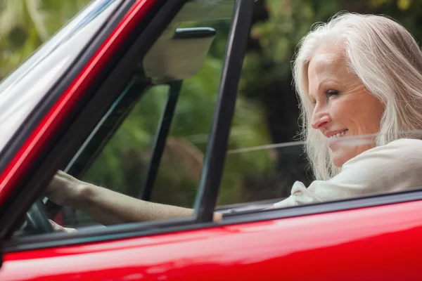 Wesoły starsza kobieta jazdy czerwony kabriolet — Zdjęcie stockowe