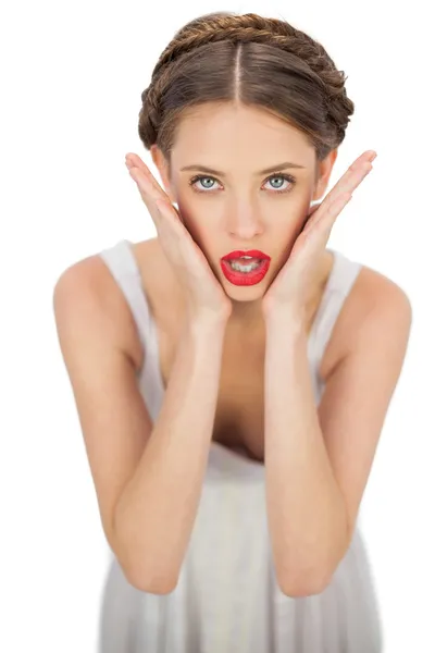 Shocked model in white dress posing holding her head — Stock Photo, Image