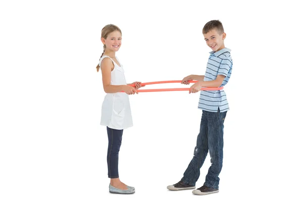 Alegre irmão e irmã brincando com hula hoop — Fotografia de Stock