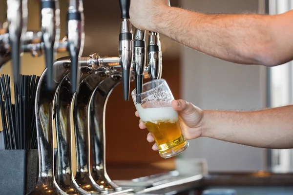 Barmans arms pulling a pint of beer — Stock Photo, Image