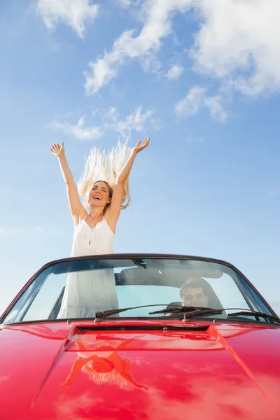 Mulher feliz de pé em cabriolet enquanto seu namorado dirigindo — Fotografia de Stock