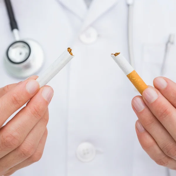 Close up on doctor breaking cigarette — Stock Photo, Image