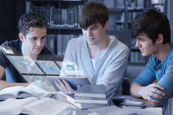 Estudantes sérios trabalhando em seu computador tablet digital — Fotografia de Stock