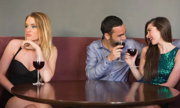 Blonde woman feeling alone as two people are flirting beside her — Stock Photo, Image