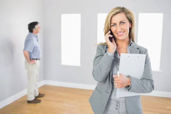 Happy realtor calling someone with her mobile phone — Stok fotoğraf