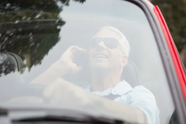 Souriant bel homme en cabriolet rouge ayant un appel téléphonique — Photo