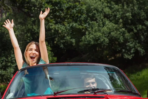Casal feliz se divertindo em seu cabriolet vermelho — Fotografia de Stock