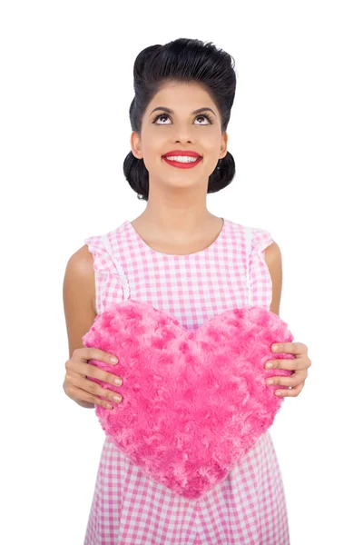 Modelo de pelo negro que sostiene una almohada rosa en forma de corazón —  Fotos de Stock