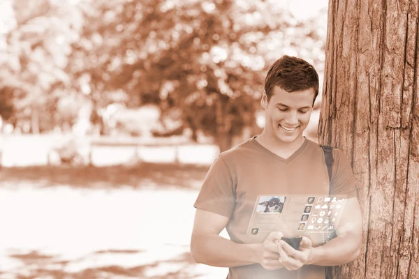 Alegre estudiante guapo usando su teléfono digital — Foto de Stock