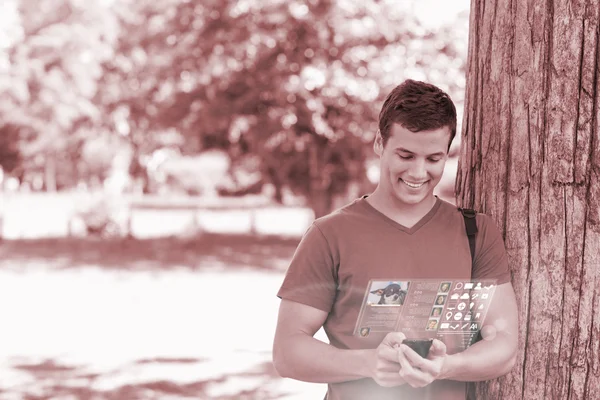 Lachende knappe student met behulp van zijn digitale telefoon — Stockfoto