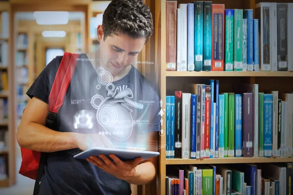 Guapo estudiante universitario trabajando en su tableta digital con interfaz futurista — Foto de Stock