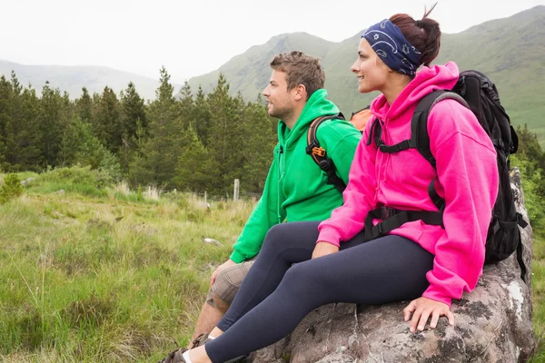 Paret sitter på en klippa som du beundrar den vackra utsikten — Stockfoto