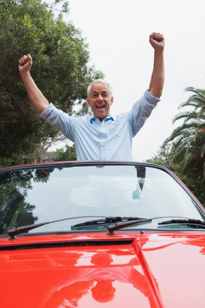 Cheerful mature man enjoying his red convertible — Stock Photo, Image