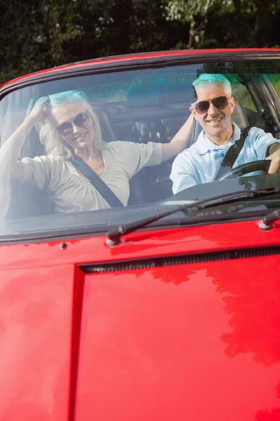 Coppia matura in cabriolet rosso sorridente alla macchina fotografica — Foto Stock