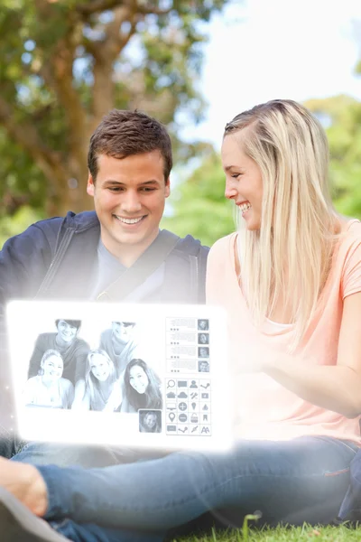 Sonriente pareja joven viendo fotos en la interfaz digital —  Fotos de Stock