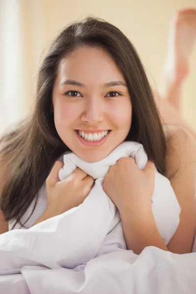 Bonito jovem ásia mulher segurando ela edredom sorrindo no câmara — Fotografia de Stock