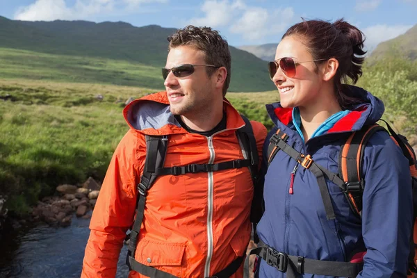 Pareja con chaquetas de lluvia y gafas de sol admirando el paisaje —  Fotos de Stock