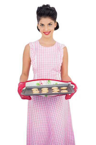 Pleased model rambut hitam memegang baking tray of cookies — Stok Foto