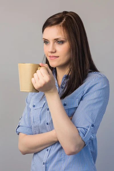 Pensiva bella bruna in possesso di una tazza di caffè — Foto Stock