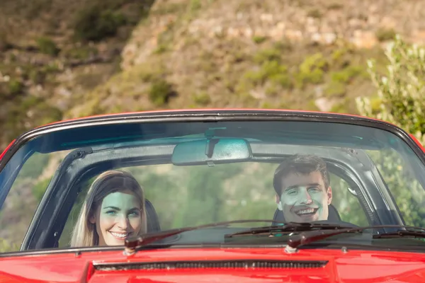 Vista frontal do casal sorridente em cabriolet vermelho — Fotografia de Stock