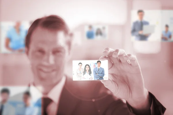 Smiling businessman showing business card — Stock Photo, Image