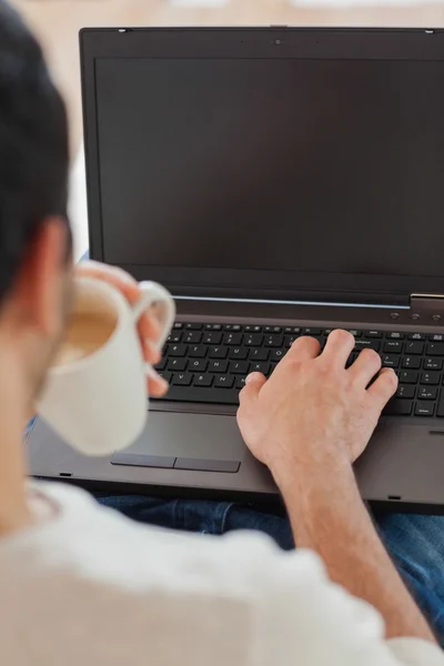 Přes rameno pohled mladého muže pomocí jeho laptop — Stock fotografie