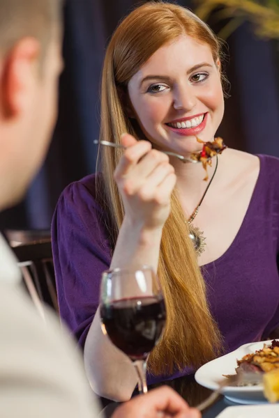 Pretty woman smiling at her husband during dinner — Stock Photo, Image