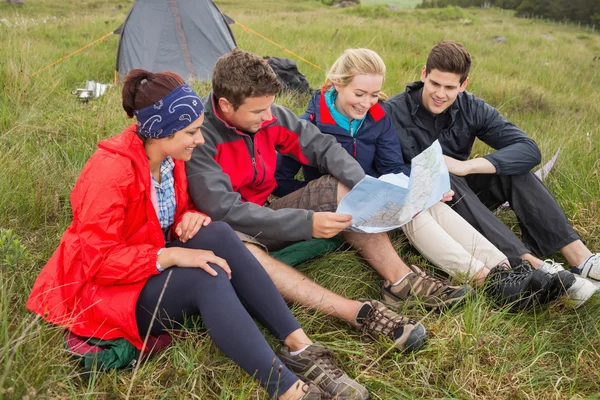 Vrienden zitten kijken naar kaart op het kamperen reis — Stockfoto