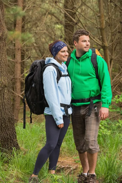 Couple souriant debout dans une forêt — Photo