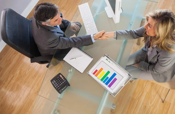 Två affärsmän med ett handslag över ett skrivbord — Stockfoto