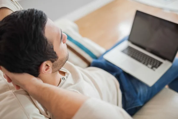 Blick aus der Vogelperspektive auf einen entspannten jungen Mann mit seinem Laptop — Stockfoto