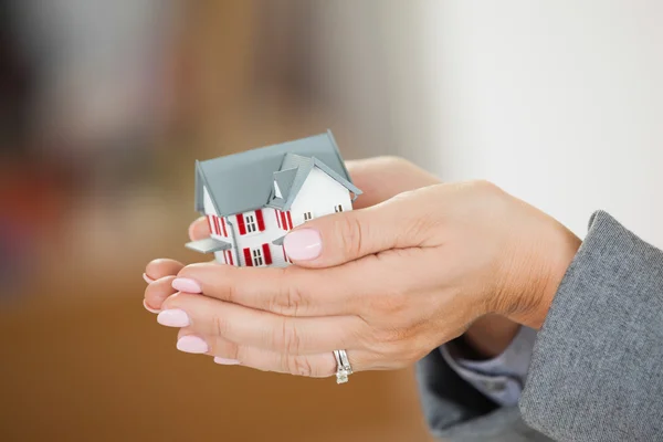 Woman holding a house in her hands