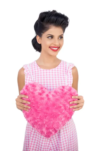 Cheerful black hair model holding a pink heart shaped pillow — Stock Photo, Image