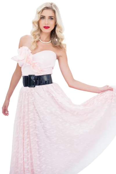 Stylish blonde model in pink dress posing holding her dress — Stock Photo, Image