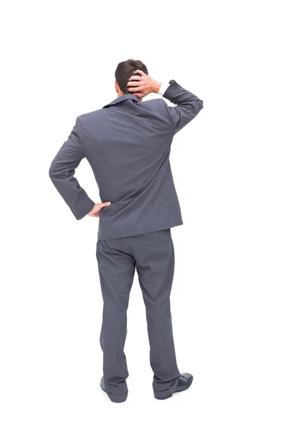 Young businessman standing back to camera scratching his head — Stock Photo, Image