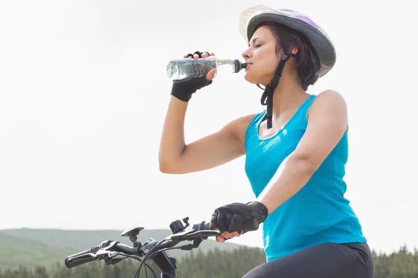 Athletic woman on mountain bike drinking water — Stock Photo, Image