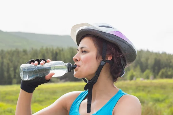 Αθλητική γυναίκα φοράει κράνος ποδηλάτων πόσιμο νερό — Φωτογραφία Αρχείου