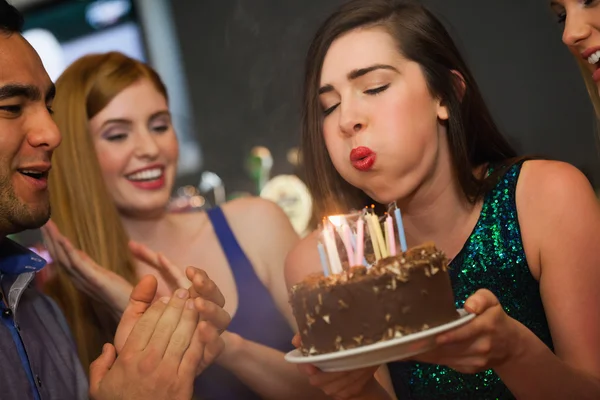迷人的女人吹着生日蛋糕上的蜡烛 — 图库照片