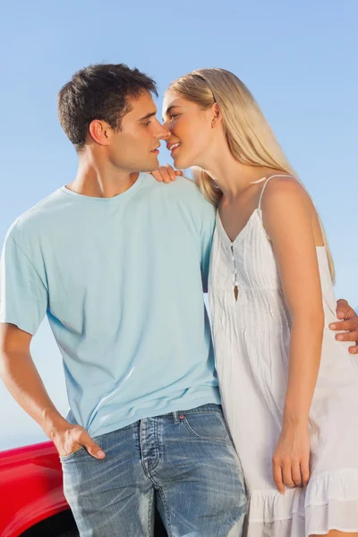 Couple mignon contre leur baiser cabriolet rouge — Photo