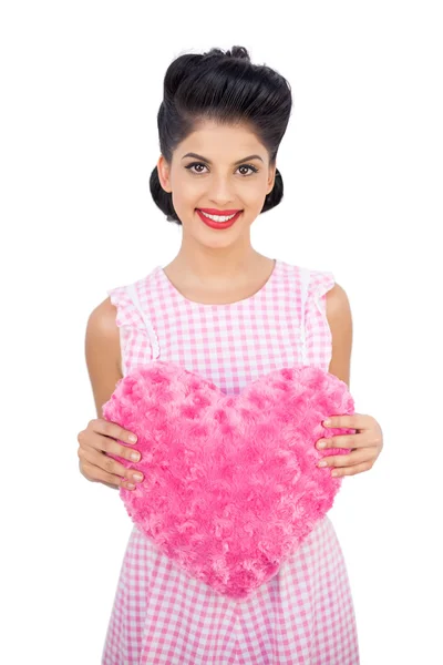 Delighted black hair model holding a pink heart shaped pillow — Stock Photo, Image